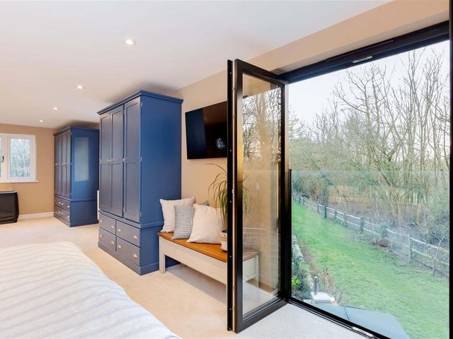 The Juliet balcony in the master bedroom overlooks the gardens and woodland