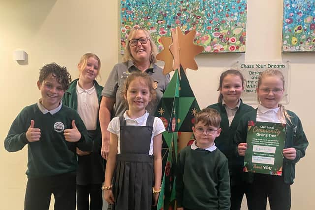 Alison Whitburn with White Meadows pupils, announcing the total raised from the Local Community Giving Tree