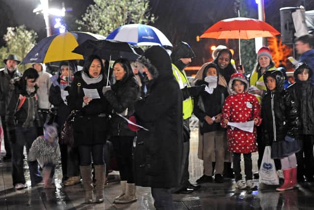 Hardy souls brave the foul weather to attend the outdoor carol service