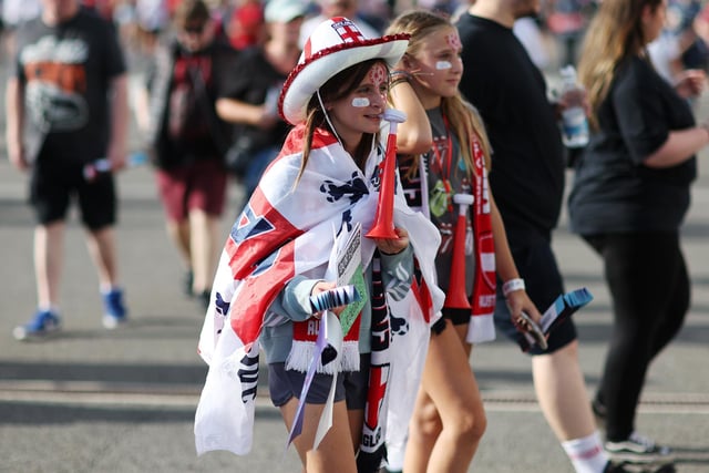 A fan wearing an England flag arrives at the stadium.