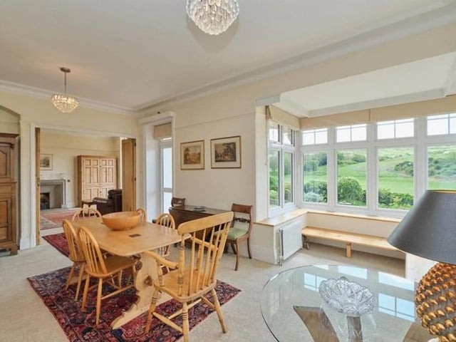 Impressive living and dining rooms, have bisecting wooden bi fold doors, and both have attractive bay windows with seating to take advantage of the infinity garden view.