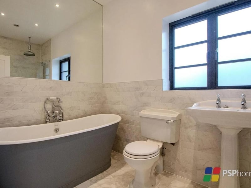 The family bathroom has a freestanding roll top bathtub