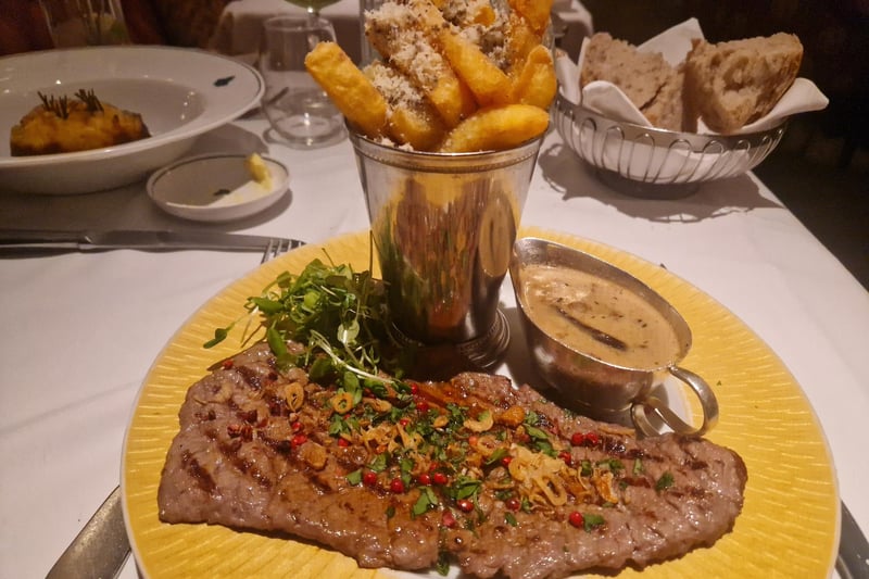 A Grilled thinly beaten beef steak with wild mushroom sauce, truffle and Parmesan chips.