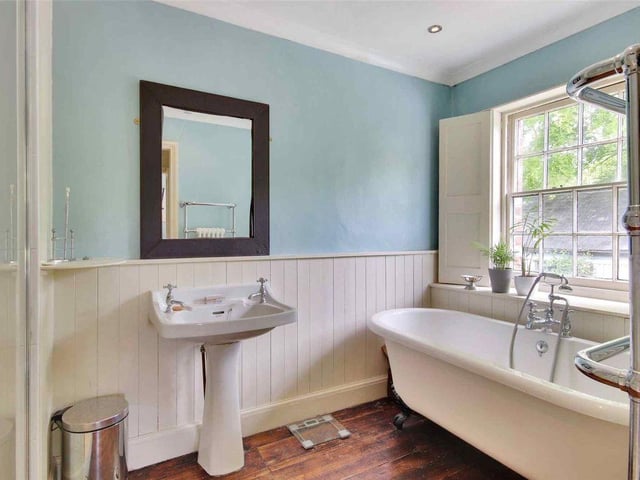 'On the south side there is a raised lawn with an outdoor swimming pool and pool house.'