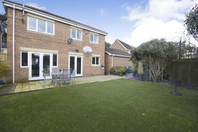 As we step outside, this photo shows the fully enclosed garden at the back. The patio area is ideal for entertaining, while the artificial lawn means low maintenance.