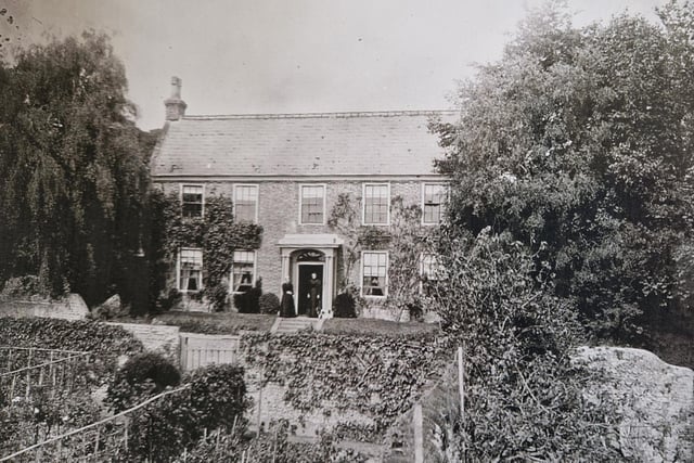 Upton Farmhouse in Sompting, seen from across the garden on the south side of West Street, with Jane Barker and her daughter in the doorway