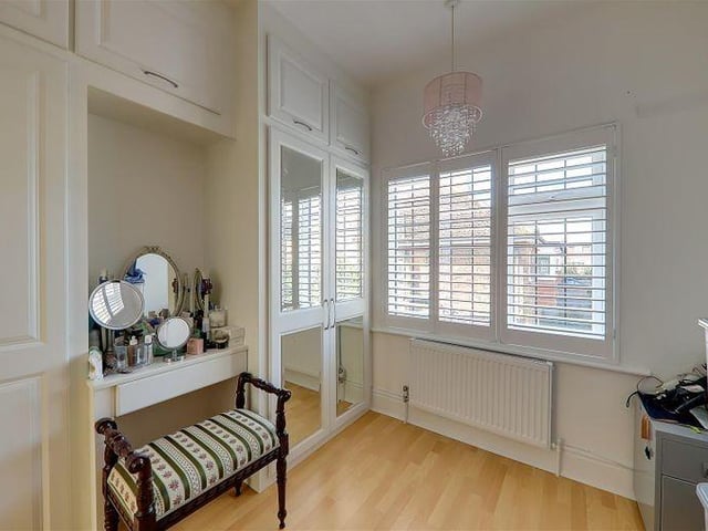 Bedroom four has fitted floor-to-ceiling wardrobes with a small dresser unit
