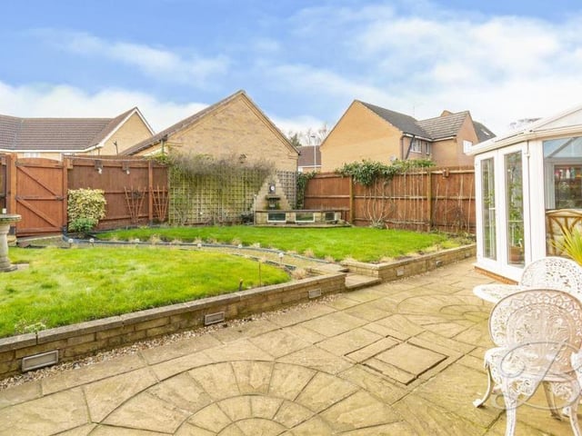 The well-established back garden from a different angle. There is a lawn, divided by a path, and it is all surrounded by fencing.