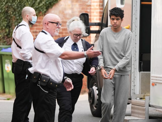 A Sussex teenager accused of murdering his father and attempting to kill a woman and a boy has been pictured arriving at court in handcuffs.