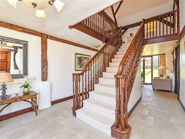 An elegant wooden staircase leads up to the rest of the property.