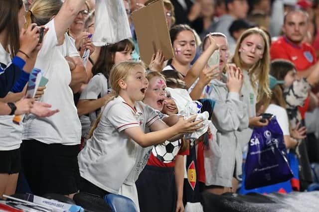 An England fan receives the shirt of Ellen White after their sides victory during the UEFA Women's Euro 2022 Quarter Final match between England and Spain at Brighton & Hove Community Stadium