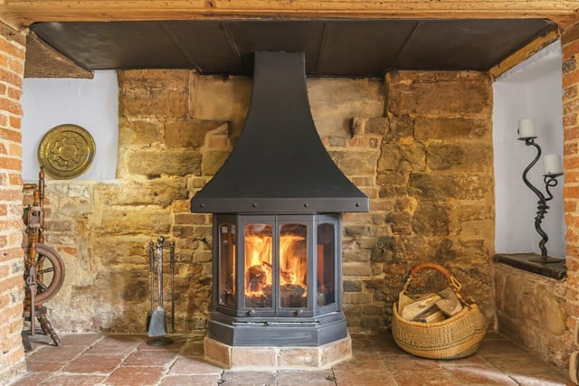 The sitting room has a feature inglenook fireplace, with an original solid wood mantel and leads into the dining room with a decorative original bread oven and further continuation of the beams