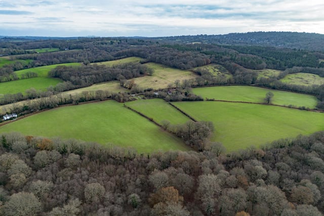 A farmhouse with farm buildings set within 119 acres on the edge of the Ashdown Forest is on the market