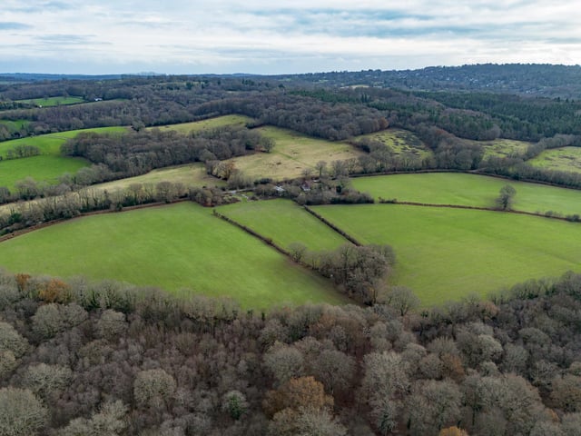 A farmhouse with farm buildings set within 119 acres on the edge of the Ashdown Forest is on the market