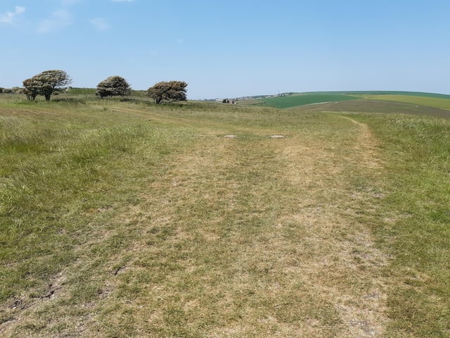 At this point look into the distance to the mast – that is roughly where we are heading! Follow the path straight down to where it meets Bazehill Road.