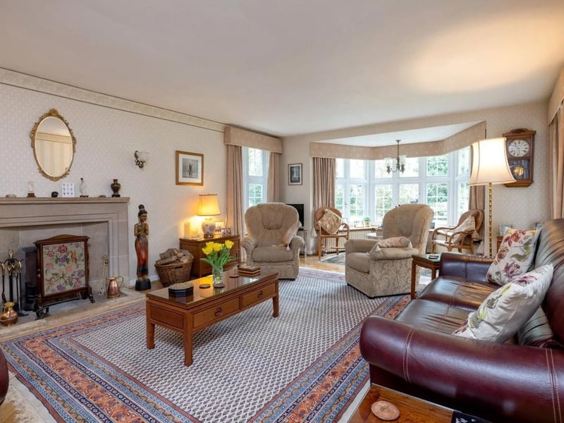 The formal drawing room has a large bay window and a fireplace