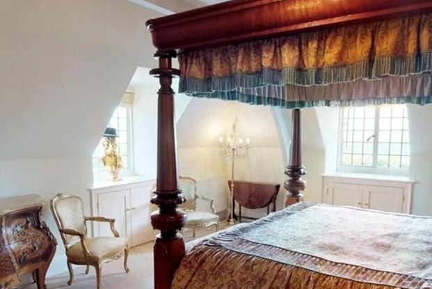 This opulent bedroom has a four poster bed