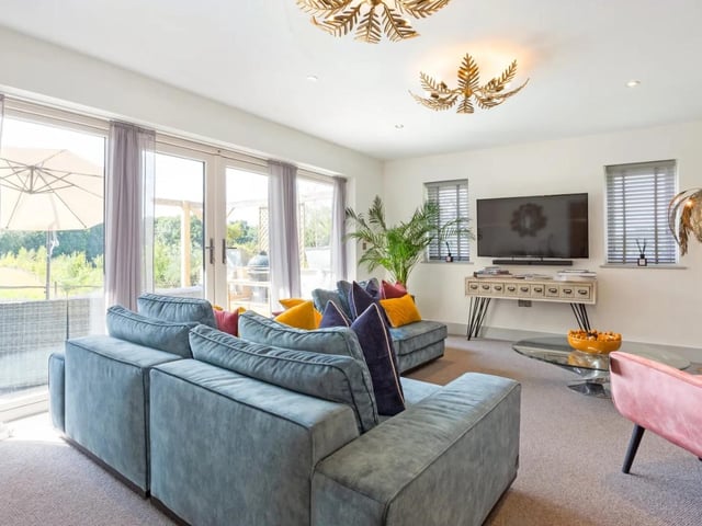 The double aspect sitting room has large glass doors leading to the west facing garden