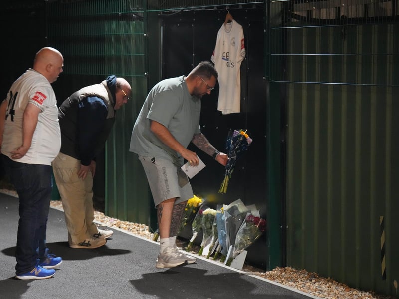 Chichester City FC and former Arsenal academy striker Billy Vigar has died after sustaining a "significant brain injury".
Vigar, 21 and born in Worthing, was injured during a game at Wingate and Finchley on Saturday in the Isthmian League Premier Division.
It is thought the injury was caused when he collided with a concrete wall, but the club has not confirmed this.
Vigar's family said on Thursday they were "devastated that this has happened while he was playing the sport he loved".
"After sustaining a significant brain injury last Saturday, Billy Vigar was put into an induced coma," the family said.
"On Tuesday, he needed an operation to aid any chances of recovery. Although this helped, the injury proved too much for him and he passed away on Thursday morning.
"The responses to the original update show how much Billy was loved and thought of within the sport." : Floral tributes to Billy Vigar are left at Chichester City FC