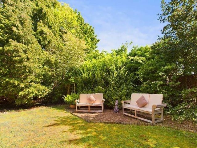 The garden is mainly laid to lawn, complemented by tree and shrub borders, a patio area and a shed