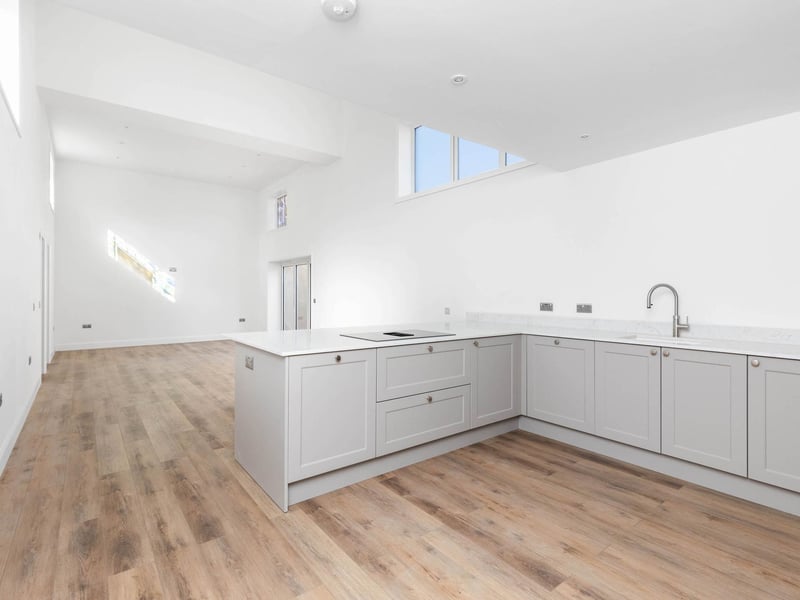 The contemporary kitchen has a breakfast bar area, stone work tops and integrated appliances