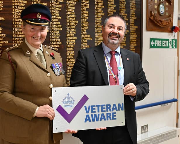 Lt.Col. Tania Cubison, medical director with James Lowell, chief executive officer, in front of The Guinea Pig Club Roll of Honour board at Queen Victoria Hospital, East Grinstead