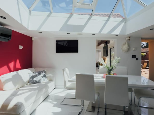 Here is the glass-roofed orangery, which is being used as a dining room. Bright and airy, it is attached to the kitchen and also has a door leading outside.