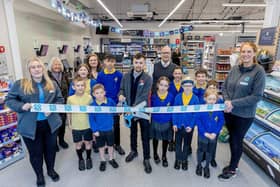 Pupils help cut the ribbon and declare the new Co-op store open