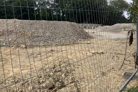 Mounds of rubble can be seen behind screening on the site of the planned new Aldi supermarket in Albion Way, Horsham. Photo: Sarah Page