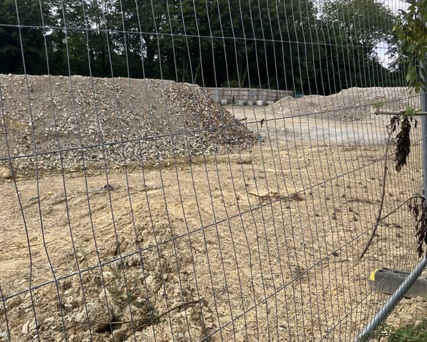 Mounds of rubble can be seen behind screening on the site of the planned new Aldi supermarket in Albion Way, Horsham. Photo: Sarah Page