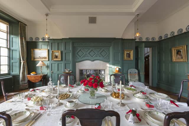 The dining table, decorated and set for Christmas dinner, in the Dining Room at Standen House and Garden, West Sussex.