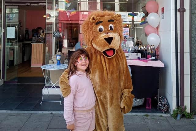The Worthing Lions mascot posed for photos with children who had their faces painted outside Jones Coffee Co on the opening day