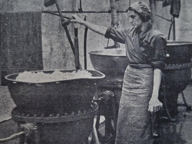 The orange peel being cooked in huge pans