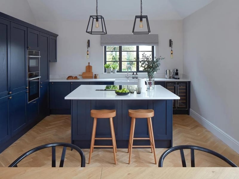 The kitchen is shaker-style with a range of wall and base units, as well as white Quartz worktops and integrated Neff appliances