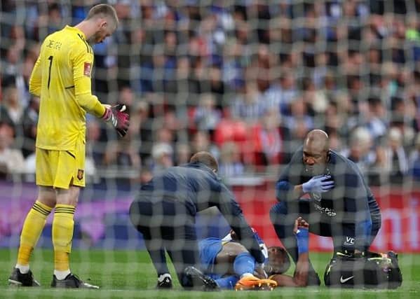 Brighton striker Danny Welbeck receives medical treatment before being substituted off injured against Man United at Wembley