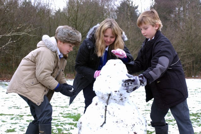 Stedham Primary School pupils Fred, Tarya and Freddie have fun making a snowman in break time