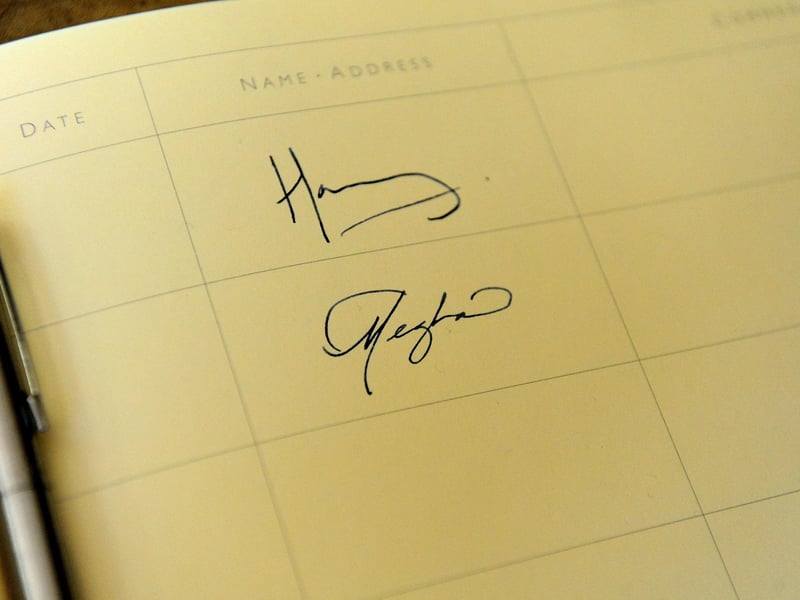 Harry and Meghan sign the guest book in Chichester