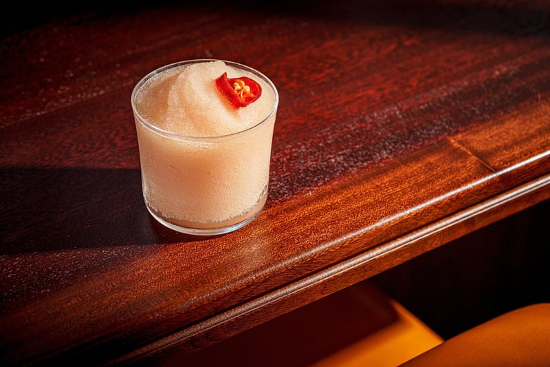 A Spicy Guava Frosé - A tumbler of rosé  ice-crush with guava fruit, and candied red chilli.