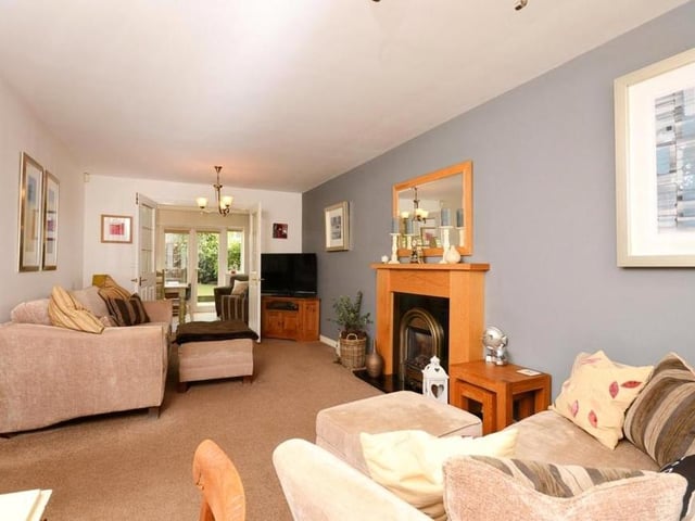 The living room invites you to relax at your leisure. It oozes comfort, with the door at the far end leading to the kitchen.