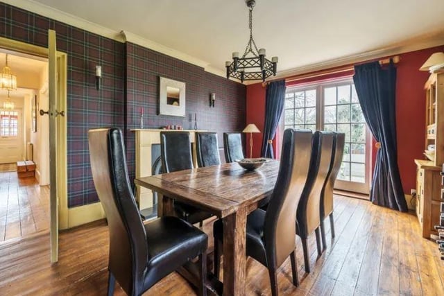 The separate dining room has solid wood flooring, feature fireplace with wood surround and mantle, and double doors leading out into the garden.