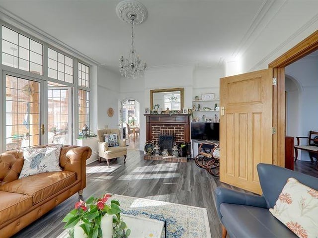 The sitting room has an open brick fireplace with wooden fireplace surround