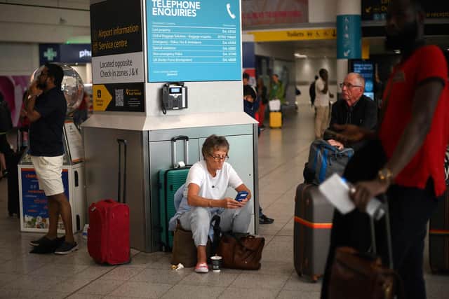 Passengers wait at Gatwick Airport after UK flights were delayed over a technical issue. (Photo by DANIEL LEAL/AFP via Getty Images)