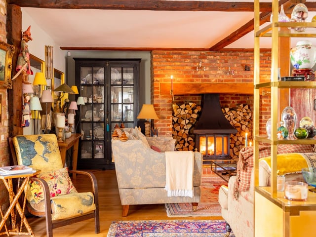 "A sumptuously sized drawing room, it lends itself to all seasons: light and airy in the summer months and cosy and embracing in the wintertime, snuggled up in front of the log-burning stove, nestled within its enormous red-brick surround. Exposed beams add character, as light flows in through several cottage style windows. Throughout the home a classic palette from Farrow & Ball and Zoffany embellishes the walls for a homely, stylish feel."