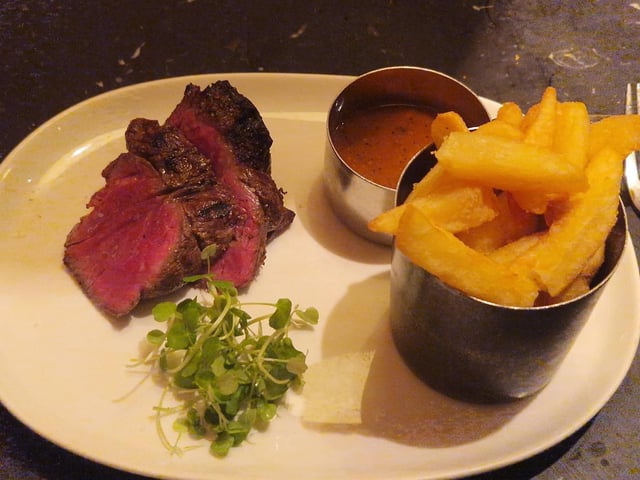 The Chateaubriand arrived in thick slices, revealing a vivid pink centre beneath a deeply browned exterior. Alongside it sat a pot piled with chunky golden chips, a separate serving of peppercorn sauce and a little greenery.