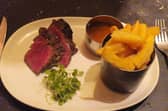 The Chateaubriand arrived in thick slices, revealing a vivid pink centre beneath a deeply browned exterior. Alongside it sat a pot piled with chunky golden chips, a separate serving of peppercorn sauce and a little greenery.