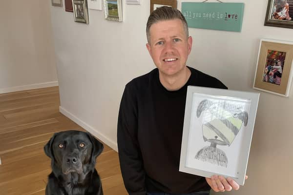 Phil Heckels, known as Hercule Van Wolfwinkle, with a pet portrait he drew to to raise money for charity