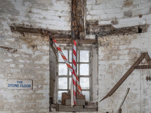 Detail of window frame on the stone floor with deathwatch beetle damage.