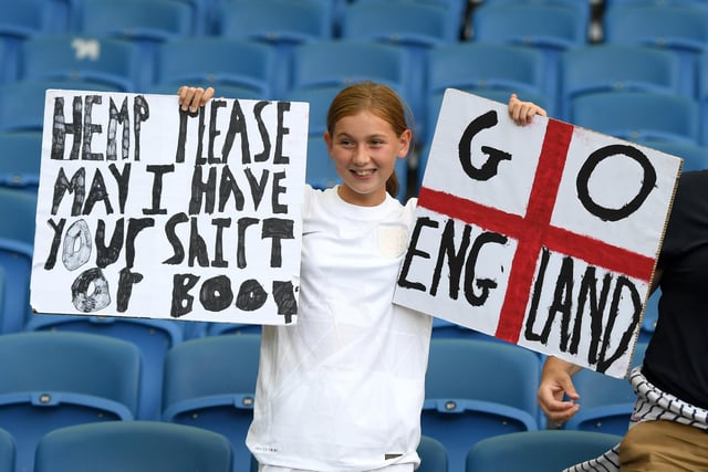 An England fan holds a banner asking for the shirt of Lauren Hemp.