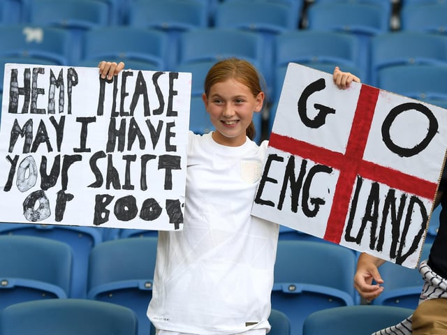 An England fan holds a banner asking for the shirt of Lauren Hemp.