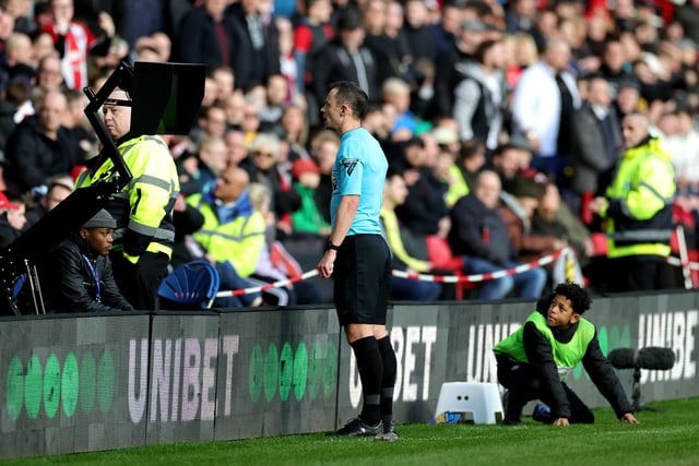 Referee Stuart Attwell  checks the VAR screen for a red card for Mason Holgate of Sheffield United (not pictured), which was later given during the Premier League match between Sheffield United and Brighton & Hove Albion at Bramall Lane on February 18, 2024 in Sheffield, England. (Photo by David Rogers/Getty Images)